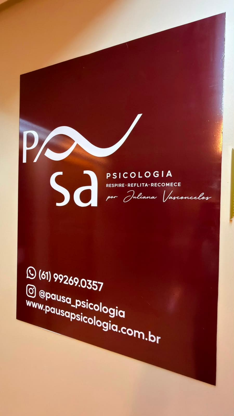 Placa da Pausa Psicologia na entrada, com logo, telefone, Instagram e site